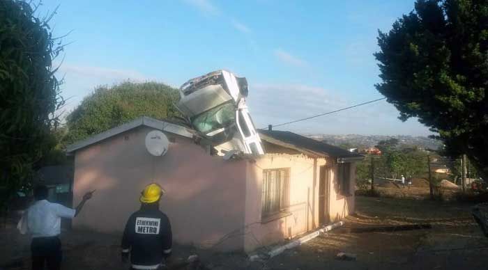 Car Lands Engine First In The Roof Of A House