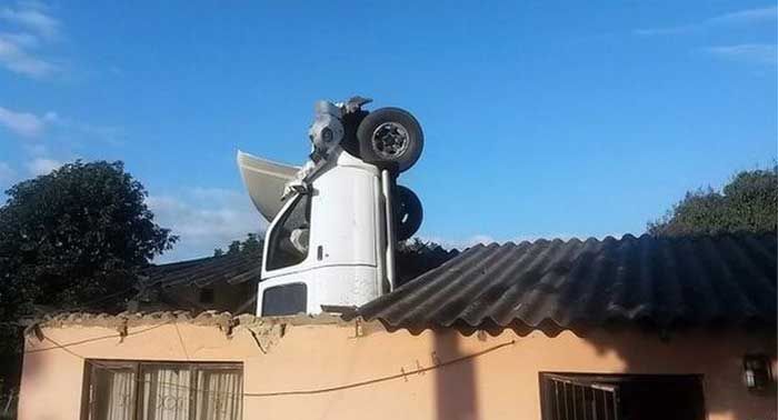 Car Lands Engine First In The Roof Of A House