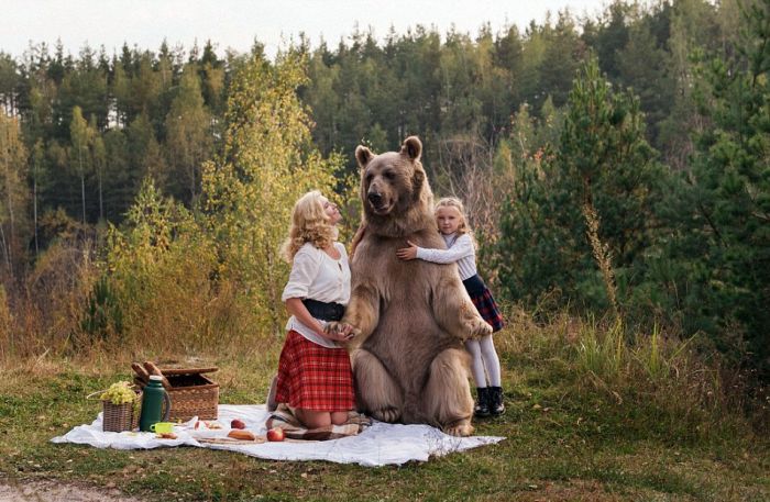 Mother And Daughter Enjoy An Outdoor Picnic With A Giant Bear