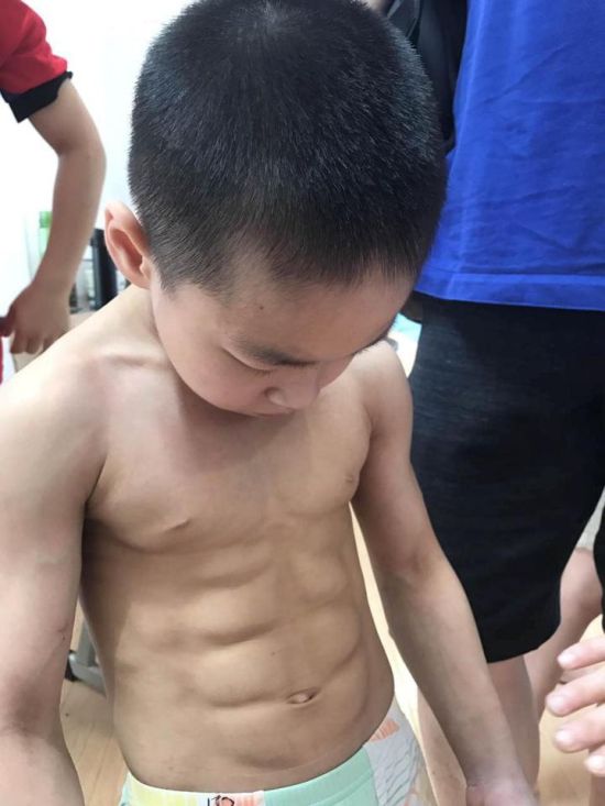 Seven Year Old Chinese Kid Shows Off His Eight Pack After Winning Medals