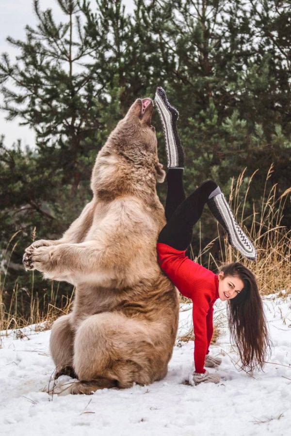 Gymnast Poses With A Brown Bear